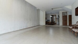 A spacious interior with a high ceiling, a dining area with chairs, and a kitchen visible in the background. - Modern Deluxe Double in Cirebon (Cirebon)