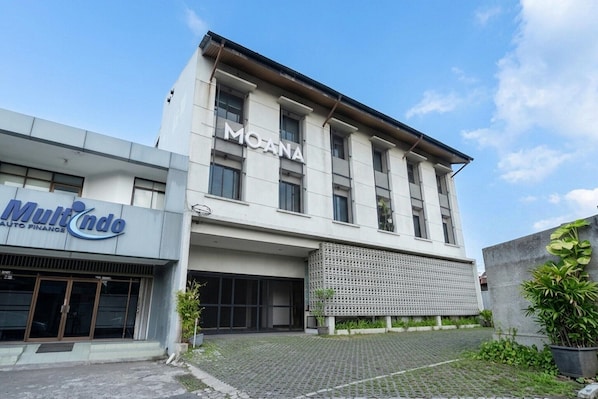 Un bâtiment sur lequel on peut lire l’inscription « MOANA », et à gauche, une autre enseigne indiquant « Multindo Auto Finance ».