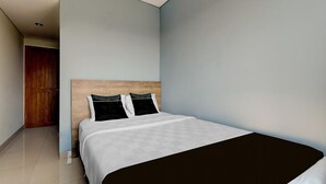 A bedroom with a bed, a wooden headboard, and a wardrobe. - Modern Deluxe Double in Cirebon (Cirebon)