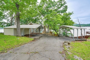 Ein Haus mit überdachter Veranda, Garage und Seeblick.