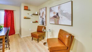 Un coin repas avec une table et des chaises en bois, un rideau rouge et un ventilateur de plafond.