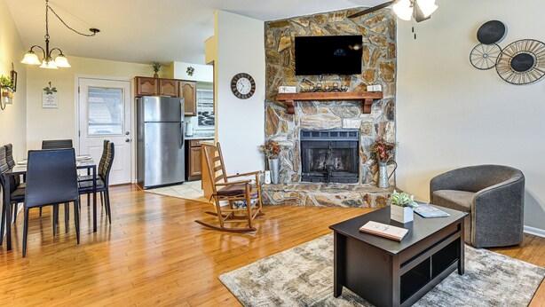 A living room with a fireplace, a dining area, and a kitchen with a refrigerator. - Walk to Lake Ariana Park! Home w/ Screened Porch (Auburndale)