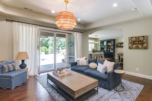 A living room with a sofa, coffee table, and a chandelier.