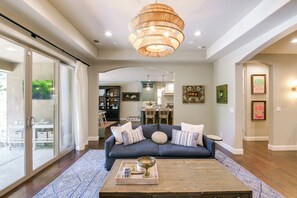 A living room with a sofa, coffee table, and a chandelier.