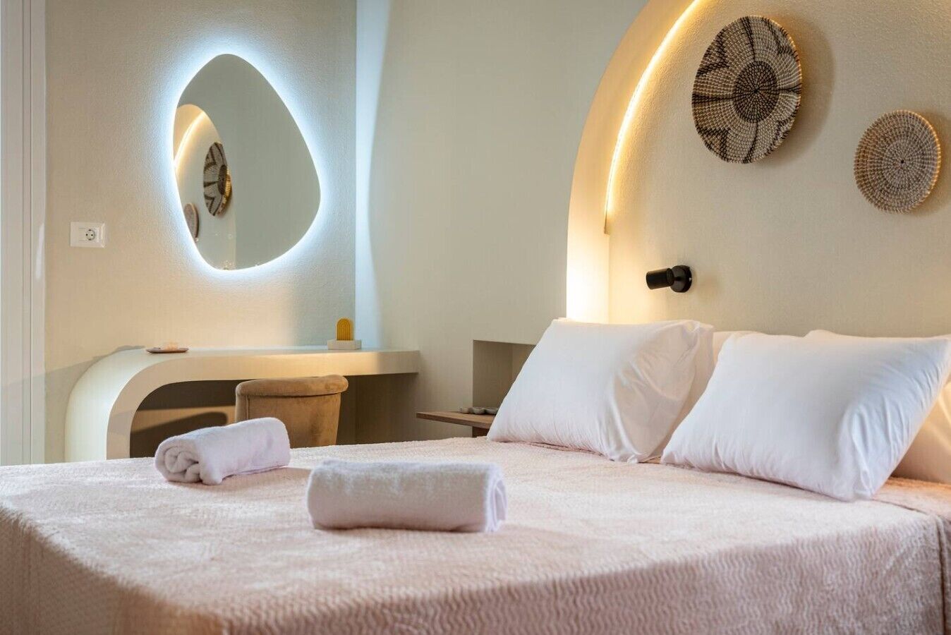 Een hotelkamer met een bed, een bureau, een stoel en een spiegel.