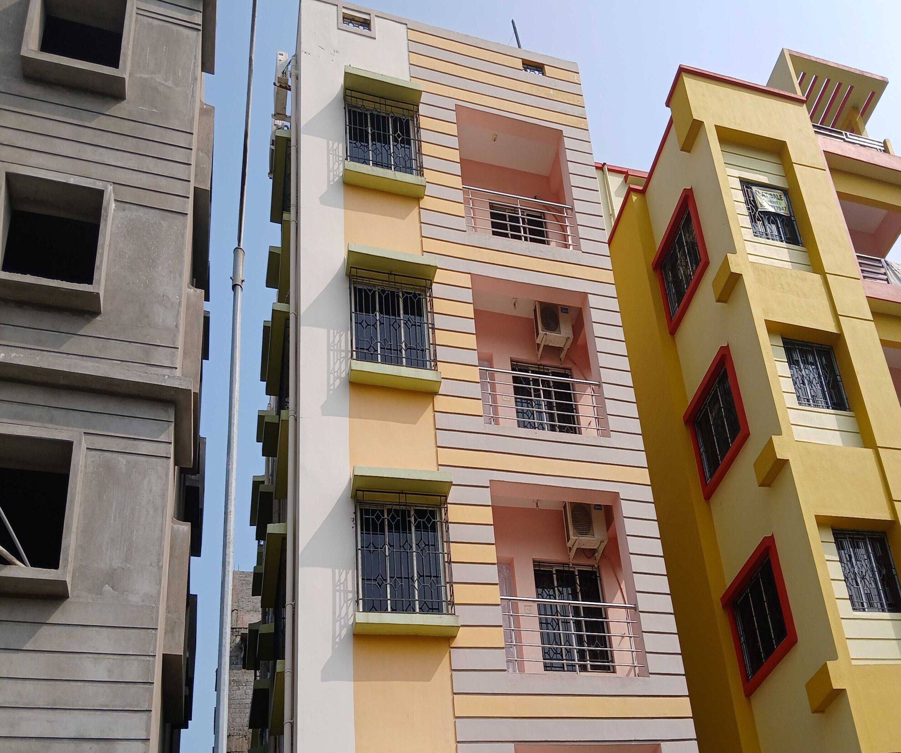 A multi-story building with balconies, air conditioning units, and a mix of window designs.