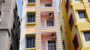 A multi-story building with balconies, air conditioning units, and barred windows. - Hotel O Park Street Metro Station (Kolkata)