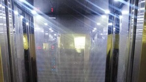 An elevator with a metallic interior and a patterned floor. - HR Residency (New Delhi)