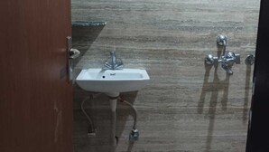 A bathroom with a sink, a shower, and a toilet. - HR Residency (New Delhi)