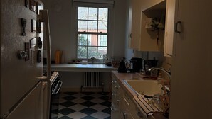 Eine Küche mit Schachbrettfußboden, einem Fenster und Schränken.