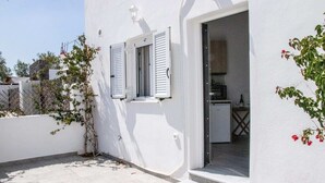 A white building with a door leading to a kitchen area. - Black Sand Santorini Studio - 20m to Perissa Beach (Perissa)
