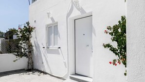 A white building with a door, steps, and a window with shutters. - Black Sand Santorini Studio - 20m to Perissa Beach (Perissa)
