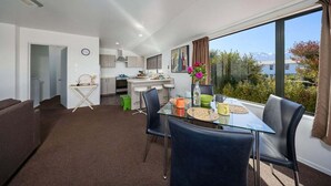 Un apartament modern amb zona de menjador, cuina i una finestra gran amb vistes.