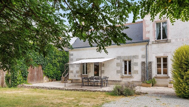 A stone house with a patio, outdoor seating, and a covered area. - Holiday Home 'Le Café De L'Encloître' with Private Terrace, Private Garden and Wi-Fi (Beaumont-Louestault)