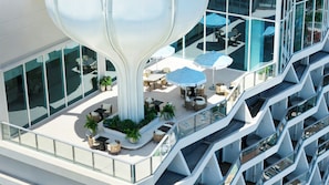Un edificio moderno con un atrio central, asientos al aire libre y varios balcones.