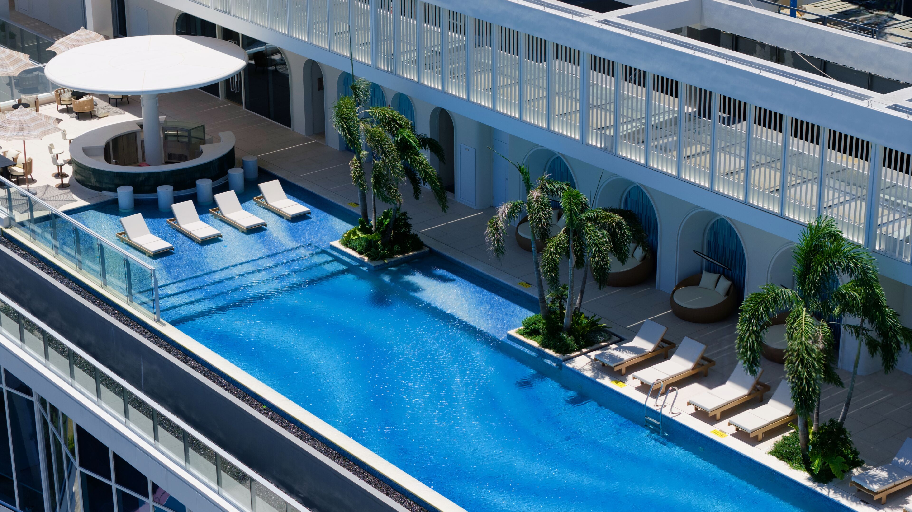 Una piscina en la azotea con tumbonas y una zona de estar circular.