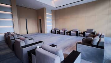 Una sala de conferencias moderna con una larga mesa, múltiples sillas y piso alfombrado.