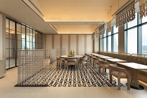 A modern dining area with a round table, multiple chairs, and a patterned floor.