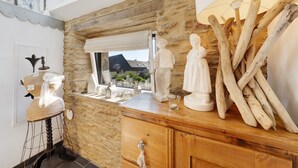 Ein Zimmer mit Steinwand, Holzmöbeln und einem Fenster mit Blick.