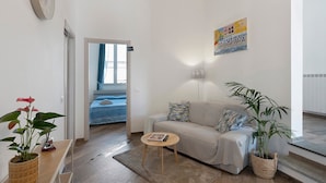 A living room with a sofa, a coffee table, and a plant. - Room 'Leone' with Mountain View, Wi-Fi and Air Conditioning (Bastia)