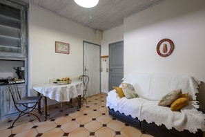 A room with a dining table, chairs, a sofa, and a bed. - 'Bel Air en Luberon' Cottage with Shared Pool and Panoramic Luberon Views (Gargas)