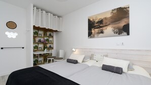 Un dormitorio moderno con una cama, una mesita de noche, una silla, una estantería con plantas y una obra de arte en la pared.