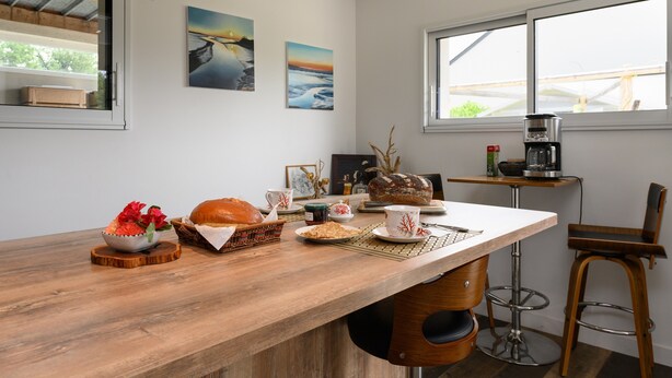 Una cocina con encimera de madera, cafetera y vistas al exterior.