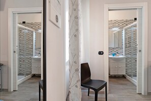 A bathroom with a mirror, sink, and chair. - Comfortable Room in Guest House (Verona)