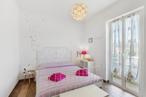A bedroom with a bed, a bedside table, a lamp, and a view through a window. - Room 'Farfalle' with Mountain View, Wi-Fi and Air Conditioning (Bastia)