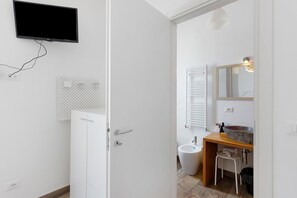 A white bathroom with a wooden vanity, a sink, and a mirror. - Room 'Farfalle' with Mountain View, Wi-Fi and Air Conditioning (Bastia)