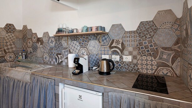 A kitchen with a modern design, featuring a coffee maker, kettle, and a shelf with cups. - Room 'Farfalle' with Mountain View, Wi-Fi and Air Conditioning (Bastia)