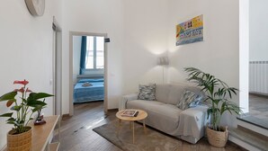 A living room with a sofa, a coffee table, and a plant. - Room 'Farfalle' with Mountain View, Wi-Fi and Air Conditioning (Bastia)
