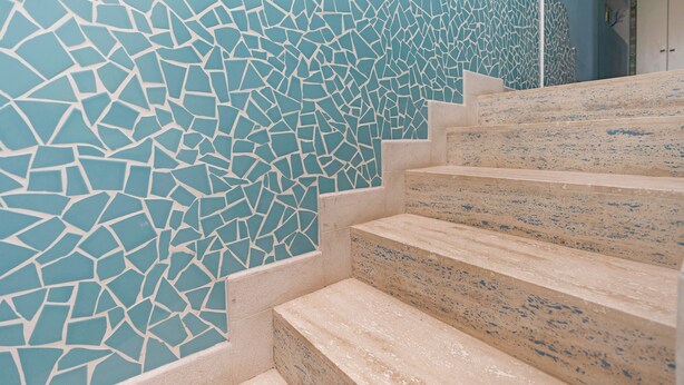 A staircase with a mosaic wall.