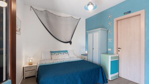 A bedroom with a bed, a nightstand, a wardrobe, and a small cabinet.