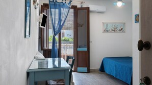 A room with a bed, a table, a chair, a TV, and a door.