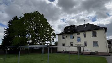 En boligbygning med fladt tag, mange vinduer og en synlig skorsten.