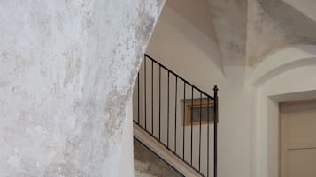 A stone staircase with a metal railing leading to a door.