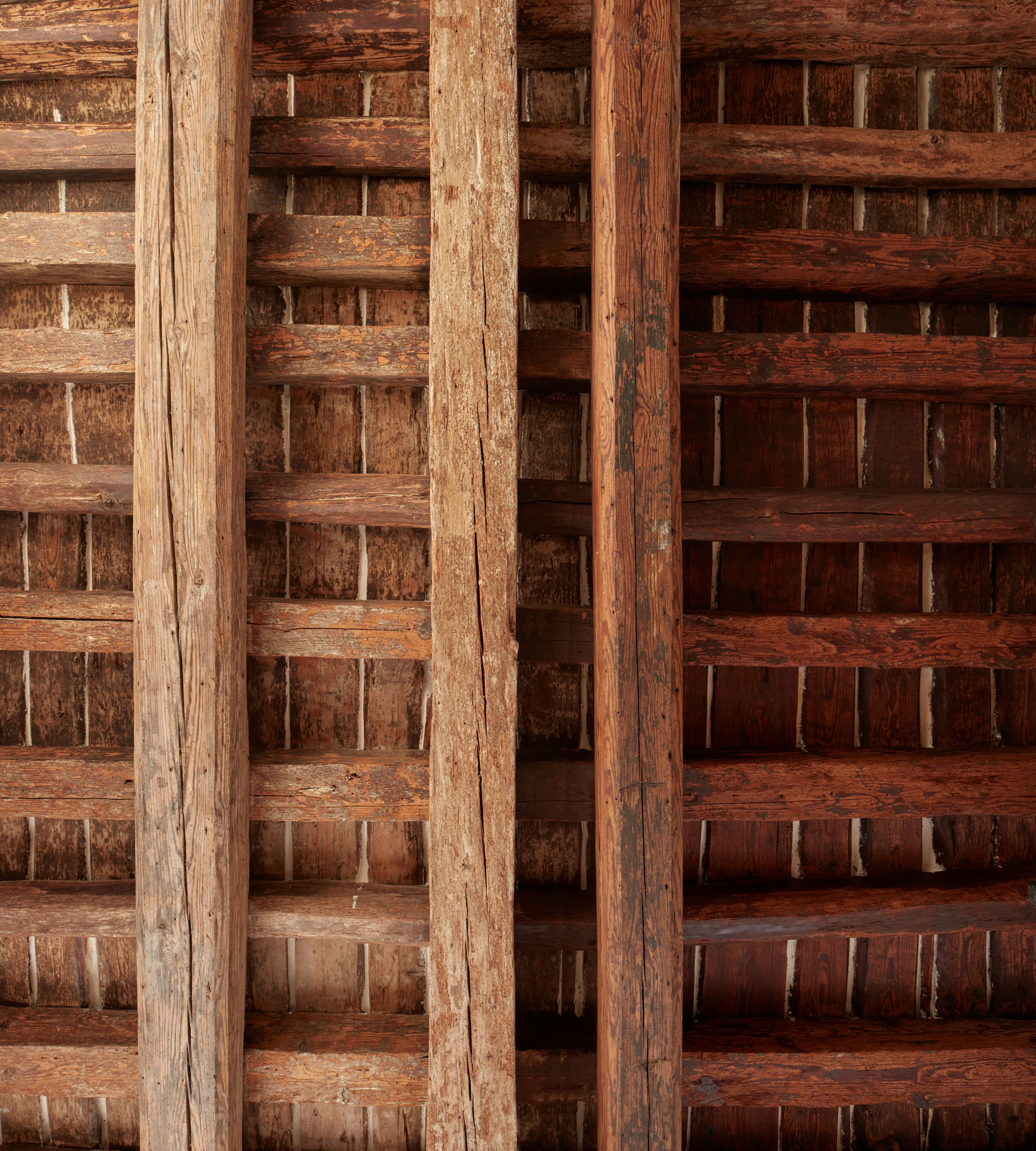 Eine Holzwand mit Rastermuster, vermutlich Teil der Innenarchitektur eines Gebäudes.