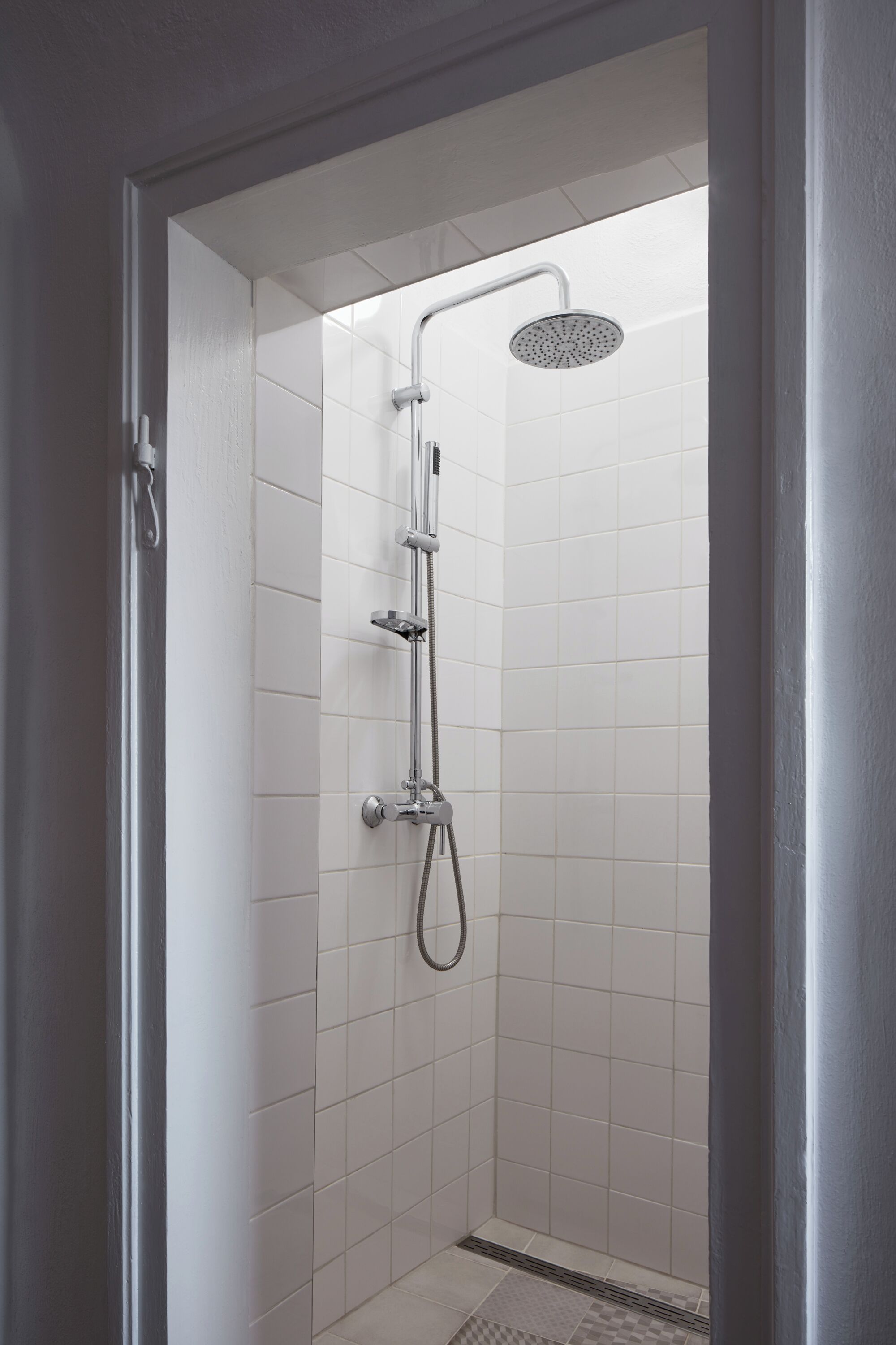 Eine Dusche mit Handbrause, Wandarmatur und Regendusche.