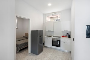 A compact kitchen with a refrigerator, oven, sink, and a small window. - Apartment 'Via Leucosia' with Sea View, Wi-Fi and Air Conditioning (Salerno)