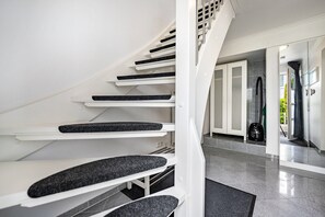 Eine moderne Treppe mit weißen Geländern und schwarzen Stufen.