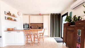 Una cocina moderna con armarios blancos, una mesa de comedor de madera y un horno empotrado.