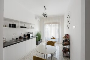 Eine moderne Küche mit Spüle, Arbeitsfläche und Essbereich mit Stühlen und Tisch.