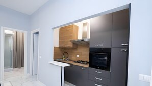 Una cucina moderna con piano cottura integrato, forno e un piccolo bancone.