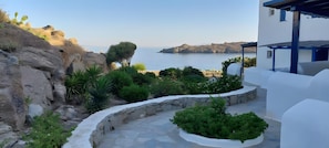 Una propietat a la costa amb un camí de pedra, vegetació i vista al mar.