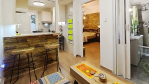 Una cucina moderna con un'area bar, sgabelli di legno e una parete decorativa in pietra.