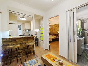Eine moderne Küche mit Barbereich, Holzstühlen und einer Wand aus Naturstein.