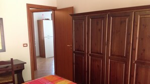 A room with two beds, a wooden wardrobe, a desk, and a chair. - Holiday Home 'Farm Holiday Sa Raighina - Right' with Shared Pool, Wi-Fi and Air Conditioning (Nulvi)