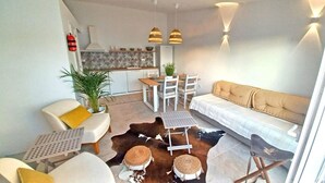 A modern living room with a sofa, chairs, a coffee table, and a dining area with a table and chairs. - Casa Lusitano With Jacuzzi by Valada Village (Valada)