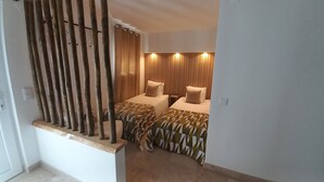 A bedroom with two beds, a wooden partition, and a wall-mounted light fixture. - Casa Lusitano With Jacuzzi by Valada Village (Valada)